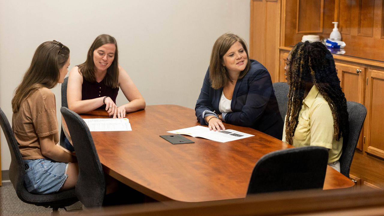 Two Geneva College employees from our Center for Calling and Career at a conference table speaking with two Geneva students.