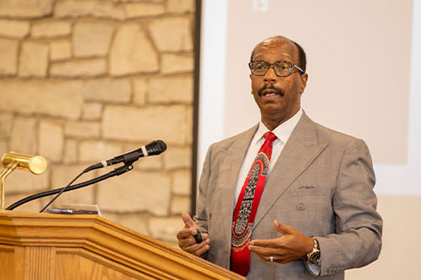 Guest speaker at Geneva College speaking behind a podium