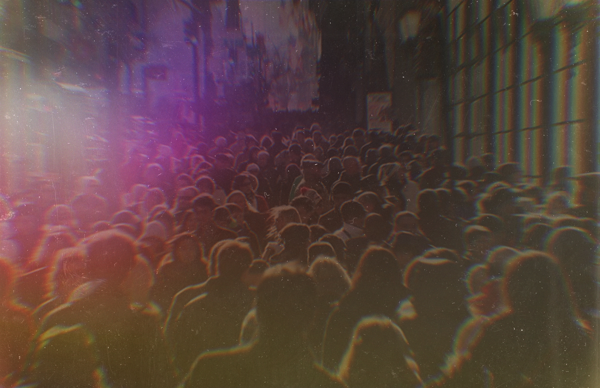 Crowd walking in one direction with a purple tint overlay