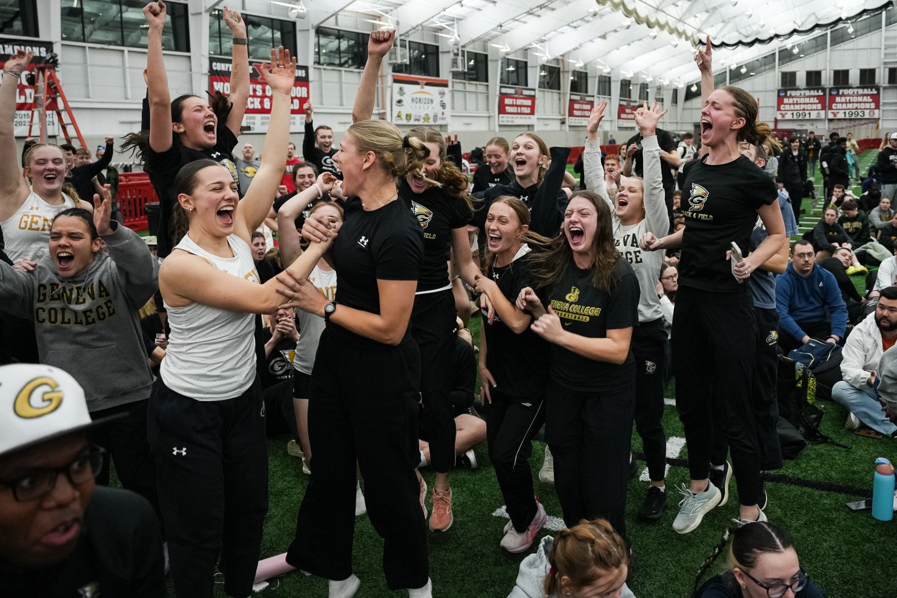 Track and field teams celebrating their indoor PAC championship