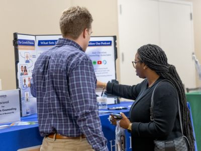 A prospective student (right) visits with Alex Hoffman (BS, 2020) from Christian Counseling Associates of Western Pennsylvania.