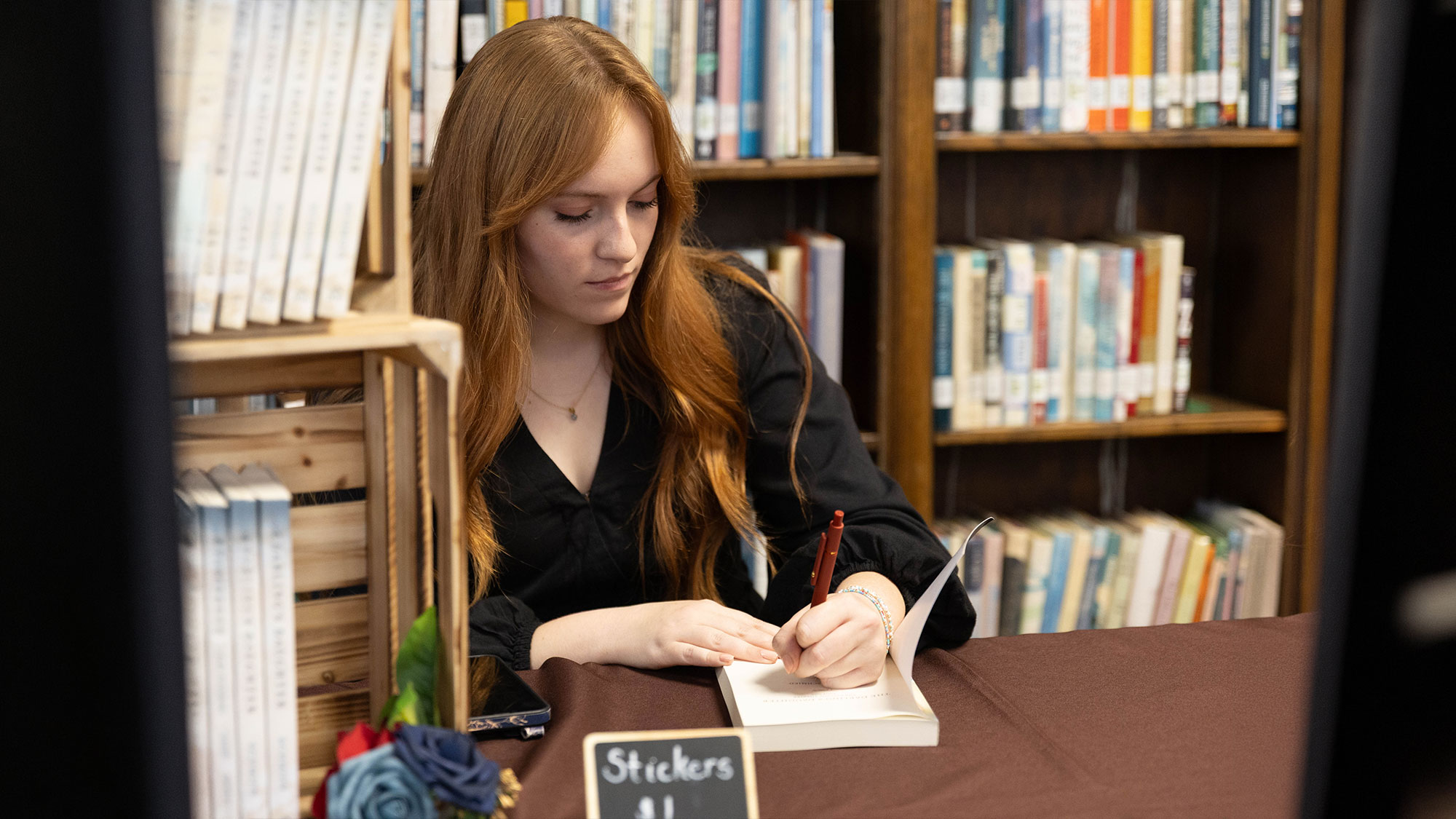 Sydney Schmied signs a copy of her book